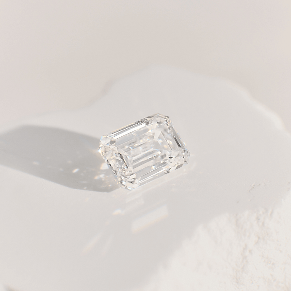 Close-up of an emerald cut diamond on a light surface, symbolising honesty, clarity, and resilience.
