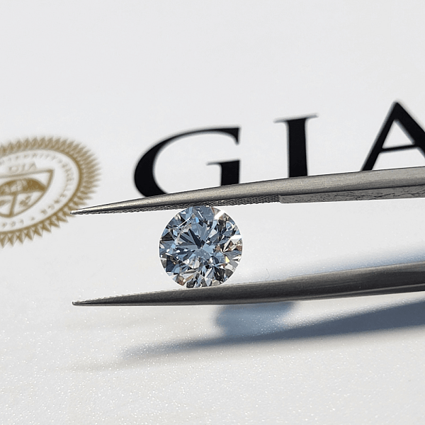 A GIA diamond grading report with a grading tool and a diamond displayed on top.