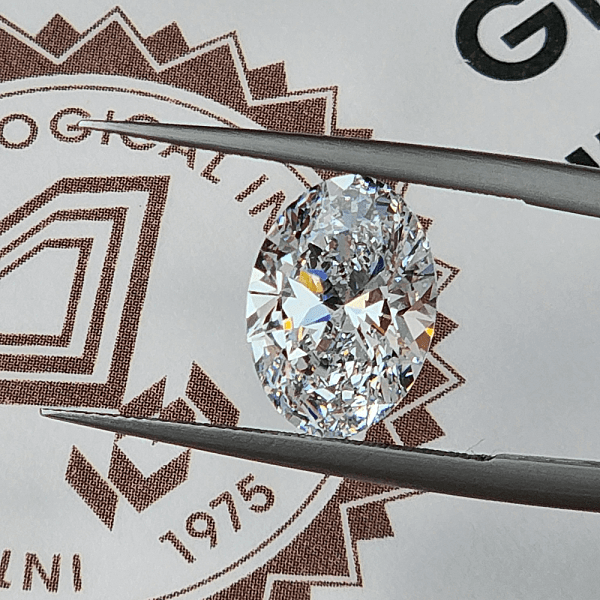 A GIA diamond grading report with a grading tool and a diamond displayed on top.