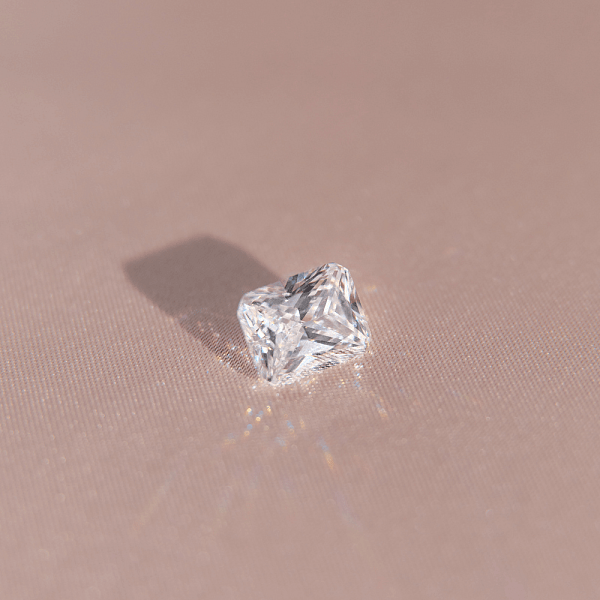 Close-up of a radiant cut diamond on a light surface, symbolising energy, vibrancy, and passion.