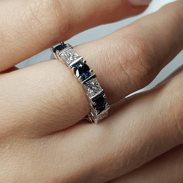 An image of a sapphire ring, worn on a woman's hand.