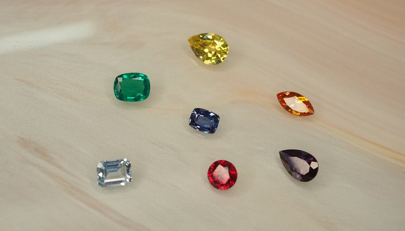 Various coloured gemstones displayed on a light surface.